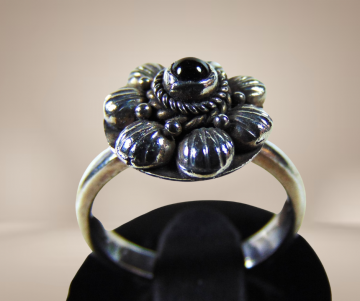 Antiek zilveren 925 kleine bloem ring granaat beige achtergrond