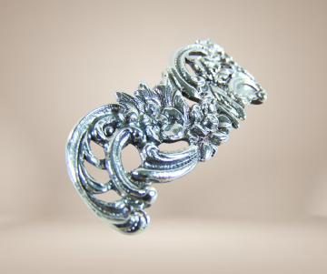 Antieke lange zilveren bloemen bogen broche 2 veranderd pluimpje rechts boven beige achtergrond