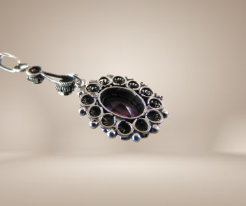 Antieke zilveren amethist glas hanger lang beige achtergrond