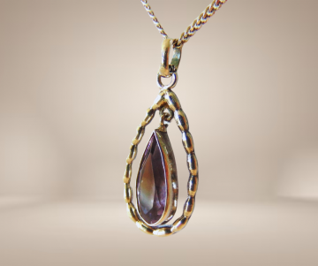 Antieke zilveren hanger druppel amethist bewegend ketting beige achtergrond 2