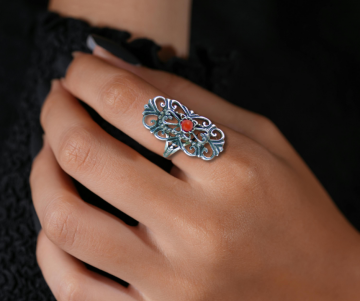 Antieke zilveren opengewerkte sierlijke lange ring koraal op hand