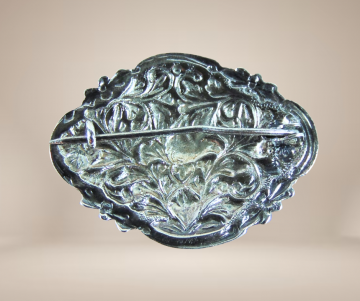 Antieke zilveren ovale ruitvorm art nouveau dichte broche beige achtergrond