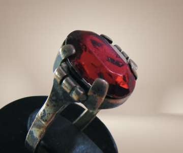 Antieke zilveren ring met patina rode glas steen breuk beige achtergrond 5