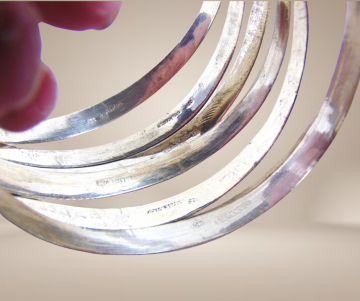 Antieke zilveren schuif armbanden gravure beige achtergrond