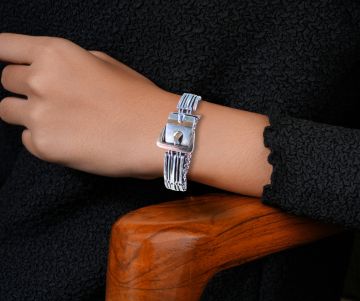 Art deco schakel sweetheart bracelet 800 zilver rose goud op arm hout stoel