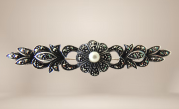 Art deco zilver markasiet faux parel bar broche beige achtergrond 2