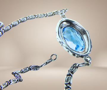 Art deco zilveren armband met blauwe paste facet steen beige achtergrond