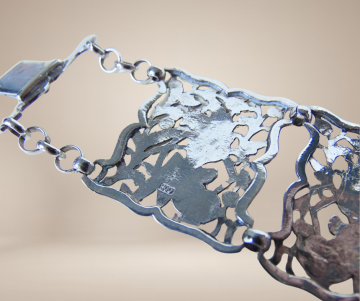 Brede antiek zilveren opengewerkte paneel armband beige achtergrond