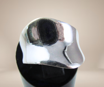 Brede modernistische zilveren asym ring glad beige achtergrond