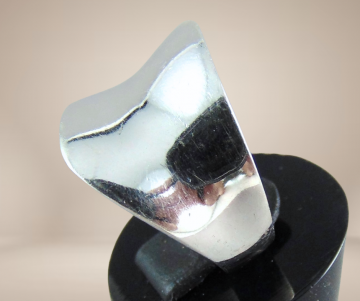 Brede modernistische zilveren asym ring glad beige achtergrond 1