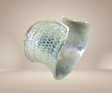 Brede zandloper zilveren cuff vlecht patroon armband zwaar beige achtergrond