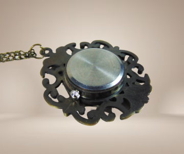 Brons kleur vintage antiekstijl horloge hanger ketting roze strass beige achtergrond 2