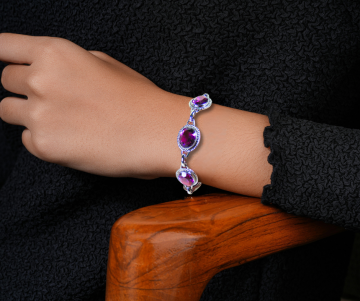 Danecraft schakelarmband paarse steen onyx op arm hout stoel