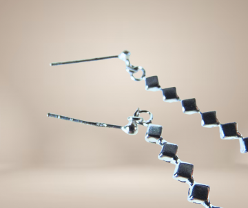 Delicate fijn zilveren lange zirkonia staafjes oorbellen beige achtergrond 1