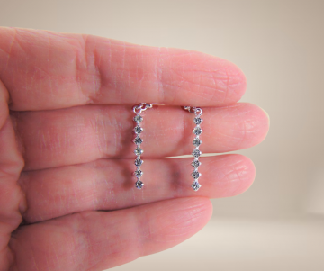 Delicate fijn zilveren lange zirkonia staafjes oorbellen beige achtergrond 2