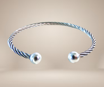 Draai kabel armband zilver knoppen beige achtergrond