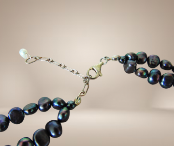 Dubbele grijze witte parelketting zilveren sluiting beige achtergrond