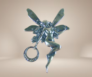 Elfje verzilverde broche art nouveau beige achtergrond