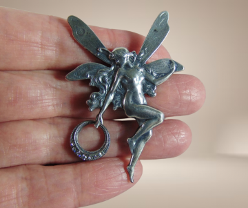 Elfje verzilverde broche art nouveau beige achtergrond 1