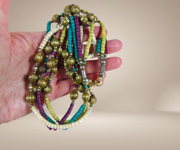 Ethnische kralen ketting turquoise wit paars koperen bewerkte kralen beige achtergrond 3
