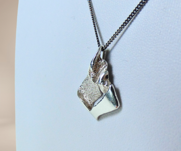 Finse akt alpo tammi koru brutalist zilveren hanger ketting beige achtergrond 1