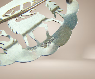 Gegraveerde zweeds zilveren rendier broche langwerpig beige achtergrond