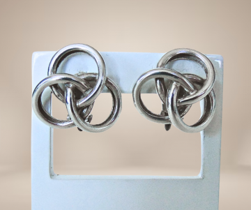 Gladde zware zilveren knoop oorbellen clips beige achtergrond