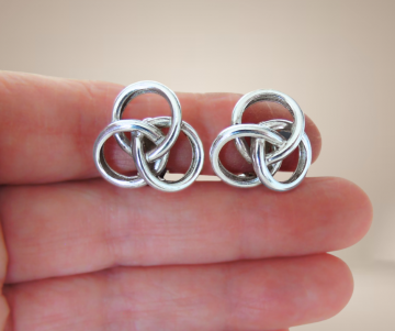 Gladde zware zilveren knoop oorbellen clips beige achtergrond  1