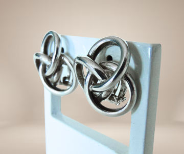 Gladde zware zilveren knoop oorbellen clips beige achtergrond  4