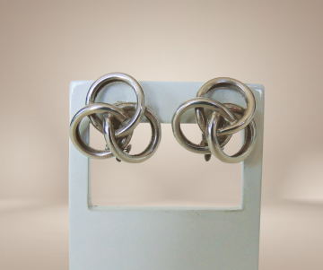 Gladde zware zilveren knoop oorbellen clips beige achtergrond