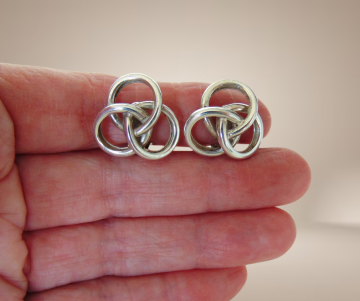 Gladde zware zilveren knoop oorbellen clips beige achtergrond 1