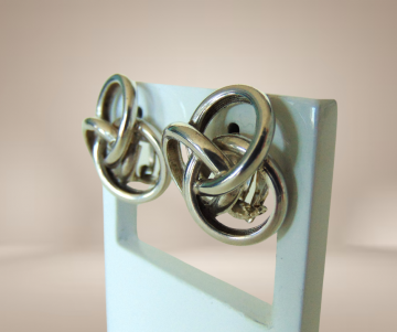 Gladde zware zilveren knoop oorbellen clips beige achtergrond 4