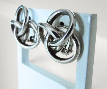 Gladde zware zilveren knoop oorbellen clips pr achtergrond 5