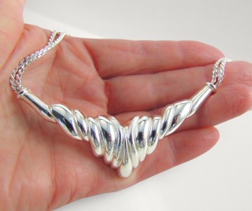 Grosse punt ketting zilver op hand beige achtergrond