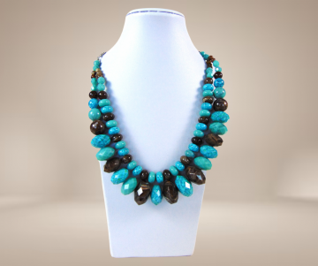 Grote dubbele streng turquoise en bruin gemeleerd facet kunststof kralen ketting beige achtergrond 3