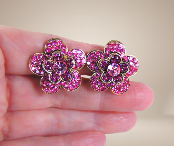 Grote knalroze strass bloem oorbellen clips beige achtergrond  2