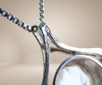 Grote modernist zilver solitair deco hanger ketting beige achtergrond