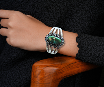 Grote navajo cuff armband groene turquoise op arm hout stoel