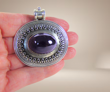 Grote ovale zilveren hanger grote amethist cabochon beige achtergrond 1