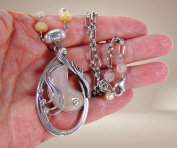 Grote supermooie zware modernistische zilver roze kwarts parel hanger ketting beige achtergrond