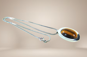 Grote teka theodor klotz modernist zilver tijgeroog hanger ketting beige achtergrond 5