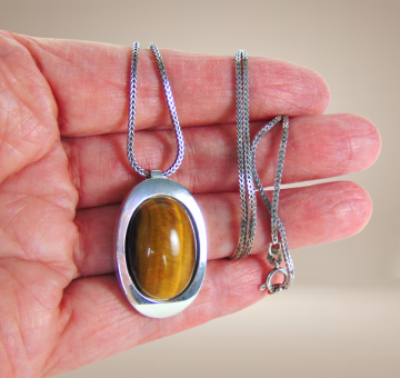 Grote teka theodor klotz modernist zilver tijgeroog hanger ketting beige achtergrond 6