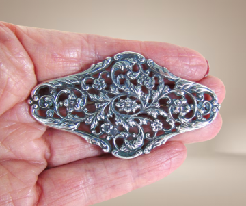 Grote zilveren antieke florale afgeronde ruit broche bloemen beige achtergrond 4