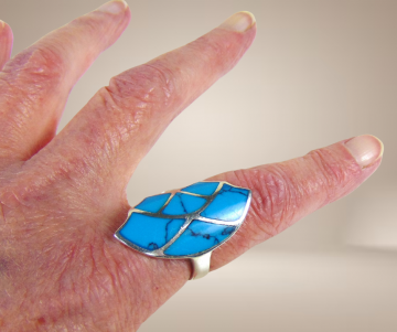 Grote zilveren asym spinneweb turquoise inleg ring beige achtergrond 1