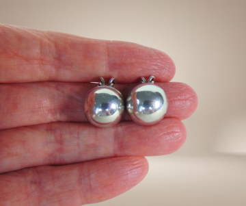 Grote zilveren bol knoppen clip oorbellen beige achtergrond 4