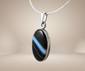 Grote zilveren hanger zwarte botswana agaat hanger ketting beige achtergrond 3