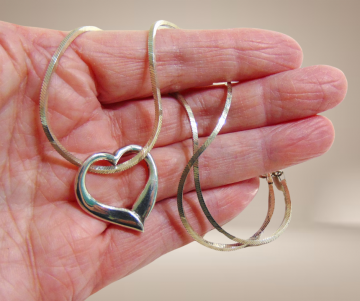 Grote zilveren open abstract hart hanger zonder oog vierkante ketting beige achtergrond 1