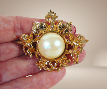 Grote zware vergulde putti engeltjes faux parel broche beige achtergrond 4