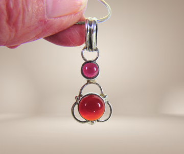 Hanger zilver carneool en granaat aan ketting beige achtergrond 2
