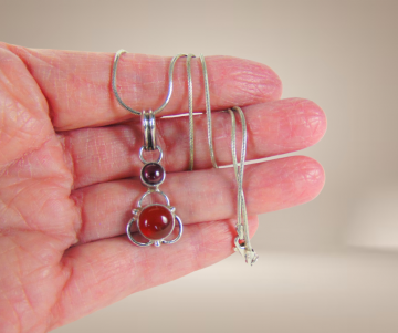 Hanger zilver carneool en granaat aan ketting beige achtergrond 5